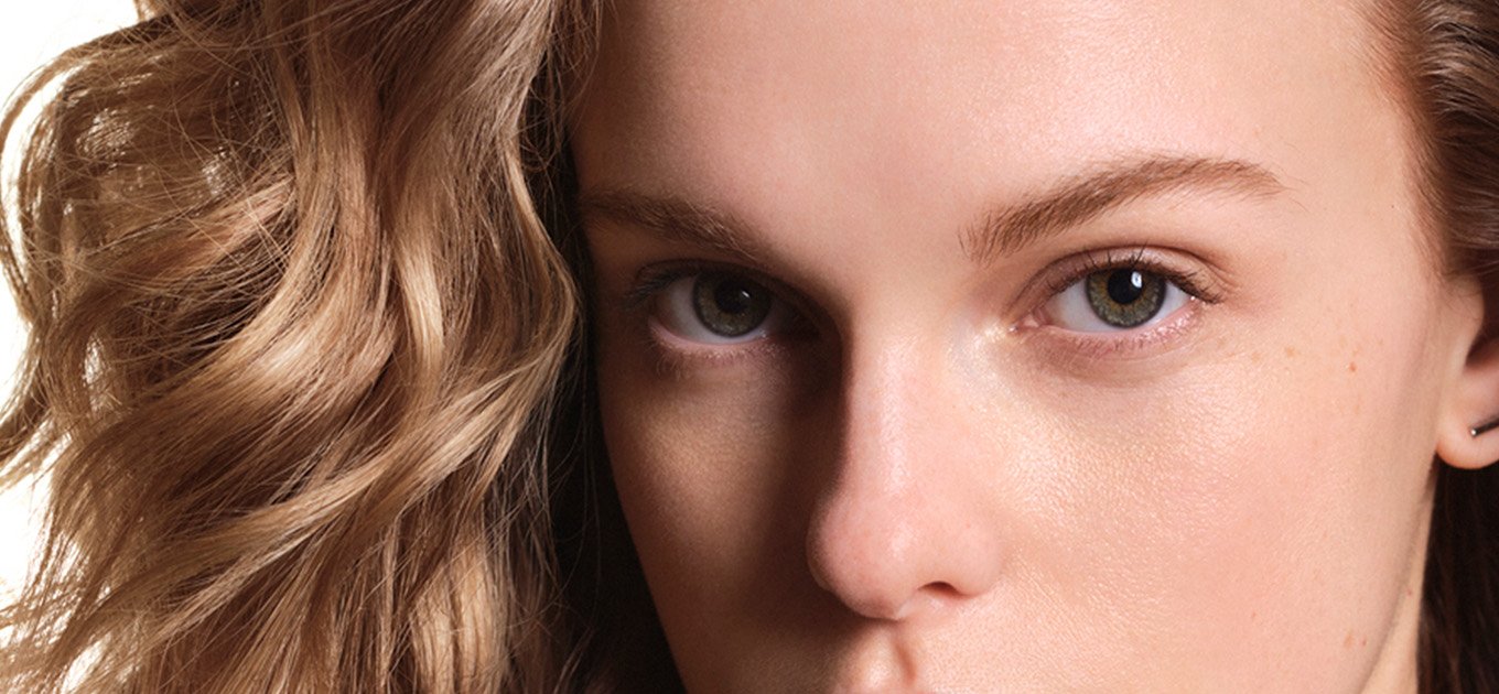 Woman with blonde wavey hair looking into the camera