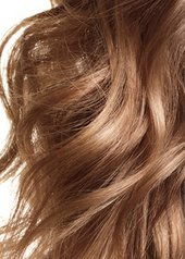 Woman with blonde wavey hair looking into the camera