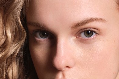 Woman with blonde wavey hair looking into the camera